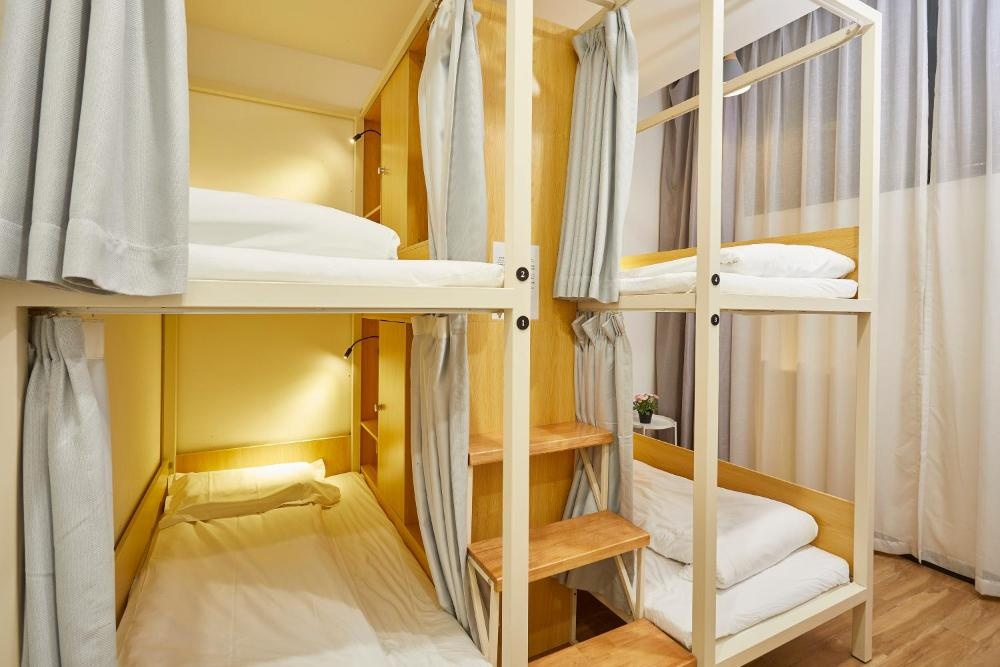 Shared dorm USB charging ports privacy curtains and wall hooks at Shanghai Hotel